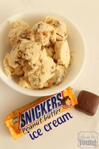 Chocolate Ice Cream Recipe by popular Utah food blog, Among the Young: image of Snickers Peanut butter ice cream in a white ceramic bowl next to a Snickers Peanut Butter bar. 