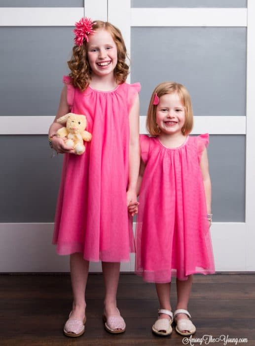 sibling loss featured by top Utah lifestyle blog, Among the Young: image of girls and bunny | Sibling Loss: 7 Essential Tips to Help your Child Grieve by popular Utah lifestyle blog, Among the Young: image of two young girls standing next to each other, wearing matching pink dresses, and holding a stuffed bunny.