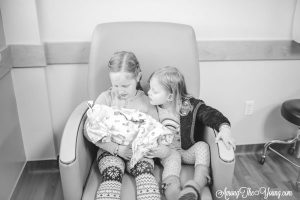 Baby girl birth story by top Utah lifestyle blog, Among the Young: image of girls holding the baby
