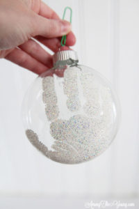 The cutest DIY handprint ornament featured by top Utah craft blog, Among the Young: image of glitter handprint