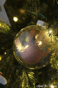 The cutest DIY handprint ornament featured by top Utah craft blog, Among the Young: image of gold ornament in tree