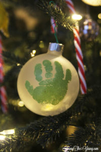 The cutest DIY handprint ornament featured by top Utah craft blog, Among the Young: image of green handprint ornament in tree