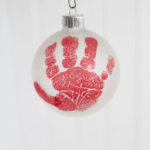 The cutest DIY handprint ornament featured by top Utah craft blog, Among the Young: image of red hand close up