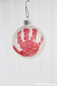 The cutest DIY handprint ornament featured by top Utah craft blog, Among the Young: image of red hand close up