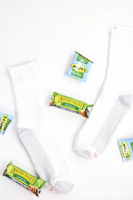 How to give back to the community this Christmas season featured by top Utah lifestyle blog, Among the Young: image of socks and granola bars |Give Back by popular Utah lifestyle blog, Among the Young: image of a socks, granola bars, and fruit snacks. 