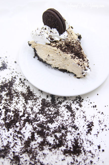 The Best easy Peanut Butter Pie by top Utah Foodie blog, Among the Young: image of messy oreos and slice of pie | Easy Peanut Butter Pie Recipe by popular Utah food blog, Among the Young: a slice of peanut butter pie on white plate that's surrounded by crushed Oreos. 