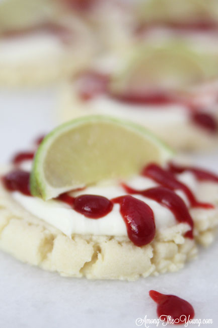 The most amazing raspberry lime sugar cookies featured by top Utah Foodie blog Among the Young: image of close up cookie with lime | Key Lime Raspberry Sugar Cookies by popular Utah food blog, Among the Young: image of key lime raspberry sugar cookies.