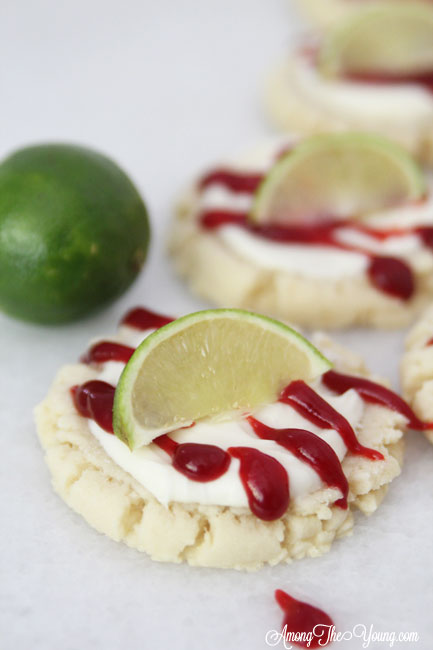 The most amazing raspberry lime sugar cookies featured by top Utah Foodie blog Among the Young: image of several cookies with a lime | Key Lime Raspberry Sugar Cookies by popular Utah food blog, Among the Young: image of key lime raspberry sugar cookies.