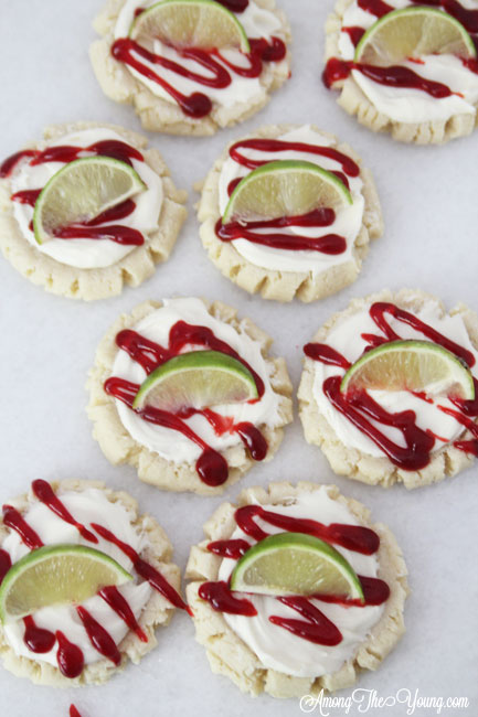 The most amazing raspberry lime sugar cookies featured by top Utah Foodie blog Among the Young: image of cookies scattered | Key Lime Raspberry Sugar Cookies by popular Utah food blog, Among the Young: image of key lime raspberry sugar cookies.