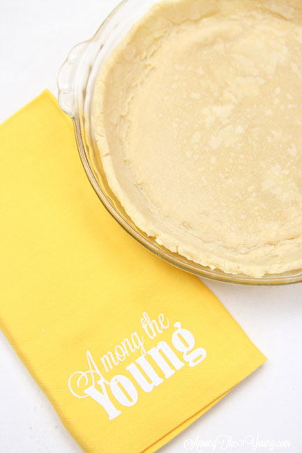 vodka pie crust recipe by top Utah Foodie Among the Young: image of pie with yellow napkin ATY |Vodka Pie Crust Recipe by popular Utah lifestyle blog, Among the Young: image of a vodka pie crust next to a yellow Among the young tea towel. 