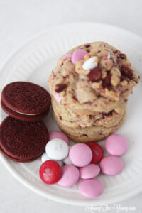 The Best Valentines Cookie featured by top Utah Foodie blog Among the Young: image of red velvet oreo cookies wiht M&Ms