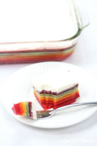 The best rainbow Jello featured by top Utah Foodie blog Among the Young: image of bite of Jello and pan