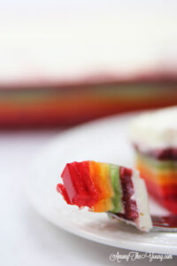 The best rainbow Jello featured by top Utah Foodie blog Among the Young: image of Jello bite and pan in background