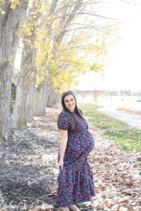 The best Non-Maternity dresses featured by top Utah fashion blog Among the Young: image of brown floral dress with a baby bump profile