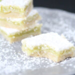 The best key lime bars featured by top Utah food blog Among the Young: image of key lime bars with a bite taken out of it